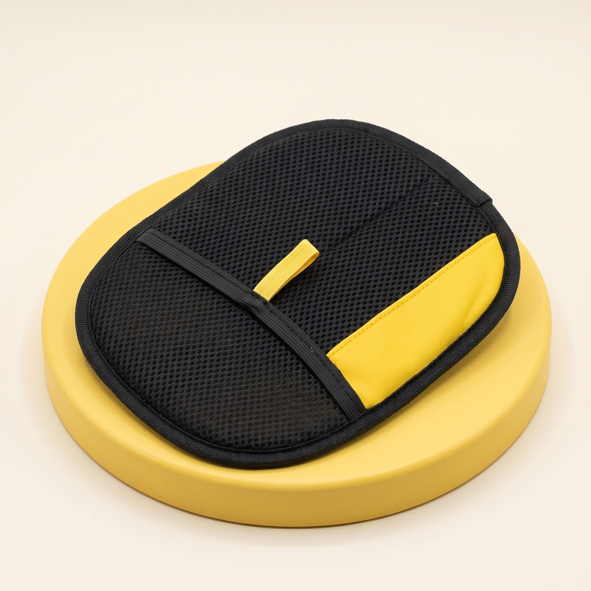 Wagello Fur Grab Mitt in black mesh with a yellow corner on a yellow stand