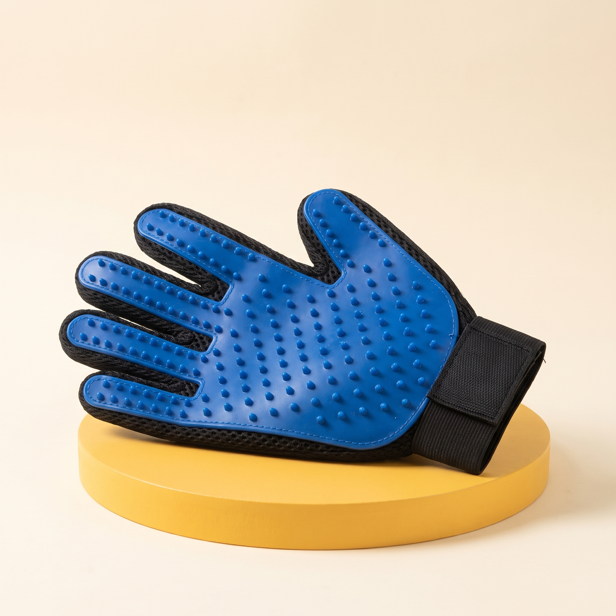 Wagello Purr Glove in blue with soft rubber nubs on a yellow stand