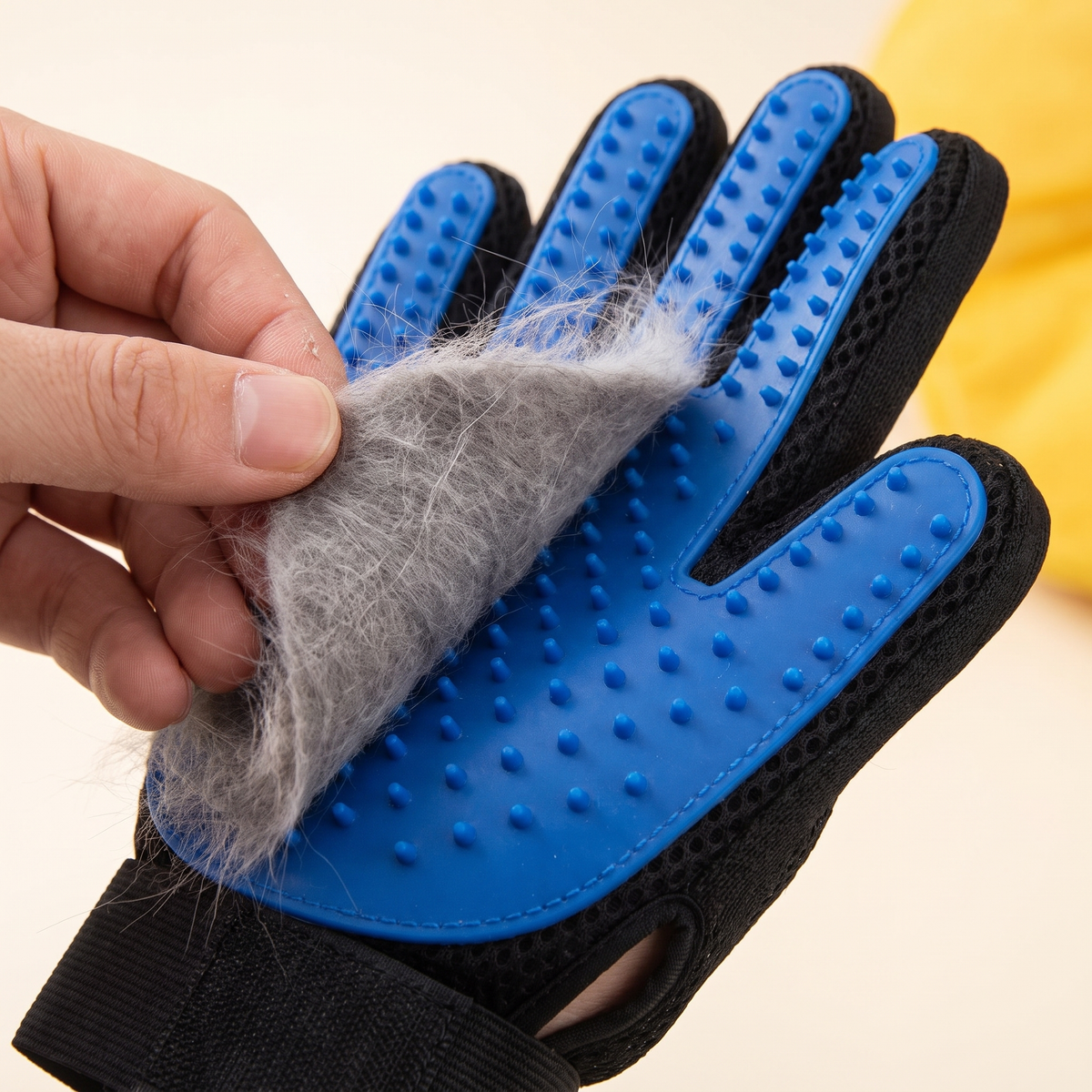 Peeling a sheet of collected cat fur off the Purr Glove in one piece