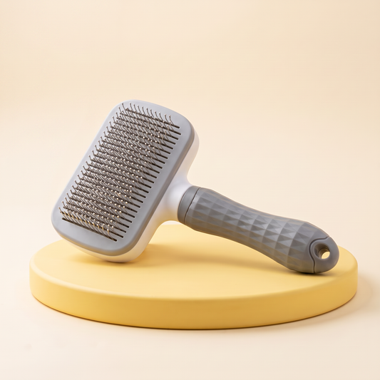 Wagello Pop Brush self-cleaning slicker brush in gray on a yellow stand