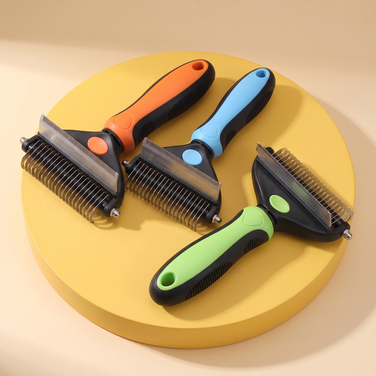 Knot Buster rakes in orange, blue and green on a yellow stand